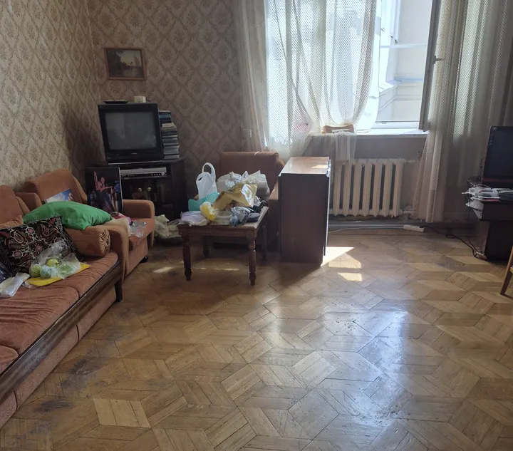 Гостиная до: старый диван и вещи на полу